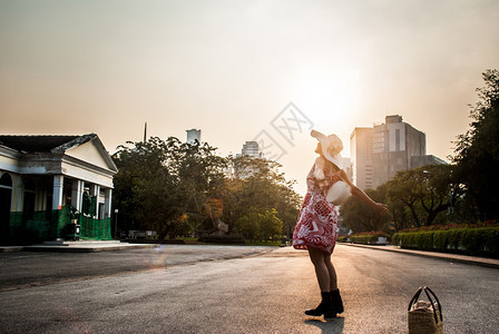 日落美丽的女青年在夏日夕阳的天空中放松户外自由风格夏天图片