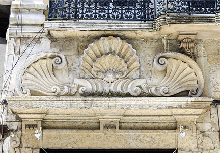 楣在葡萄牙里斯本市中心一座旧楼的门顶上可以看到优雅的装饰古老陈列花纹或表情建造后柱背景图片