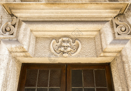 细节楣在葡萄牙里斯本市中心一座旧楼的门顶上可以看到优雅的装饰古老陈列花纹或表情古典图片