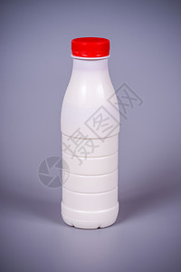 乳制品牛奶在塑料瓶里灰色背面有红塞子包装农场图片