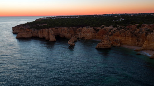 日落时断崖海洋的美丽风景图片