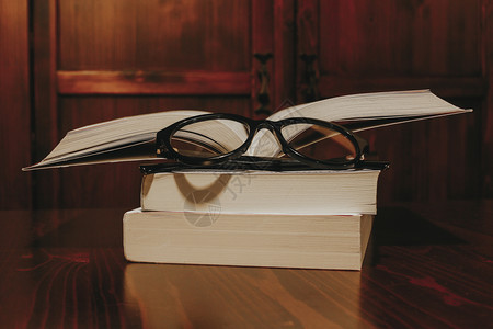 叠放的书本和上面的眼镜图片