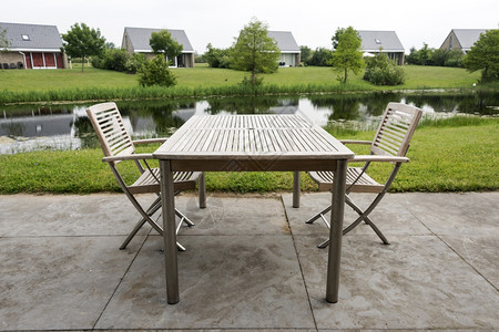 在靠近水的节假日用木制椅子和桌放松座位绿色假期图片