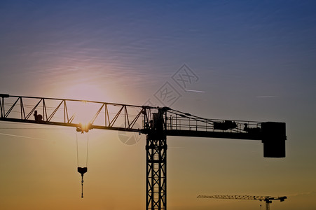 电梯船厂地点日出时在建筑工地的起重塔图片