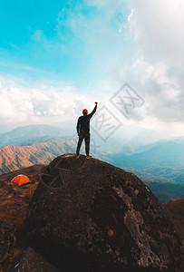 伸手触碰天空的登山者图片