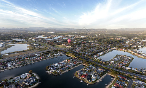 在澳洲昆士兰州金海岸的运河上空出现一个热气球在日出时飞过澳大利亚行风景优美图片