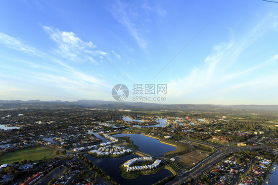 房屋风景优美在澳洲昆士兰州金海岸的运河上空出现一个热气球在日出时飞过水图片