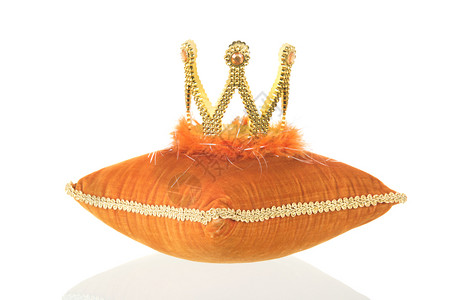 王冠金的橙色皇家天鹅绒枕头皇冠与白色背景隔绝工作室图片