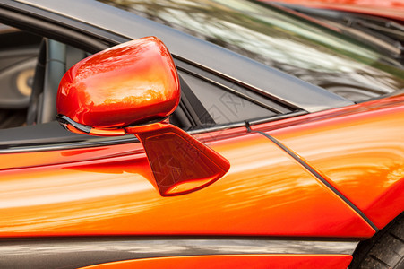 闪亮的奢华跑车在一辆明亮橙色豪华运动车上关闭了一面驾照镜图片