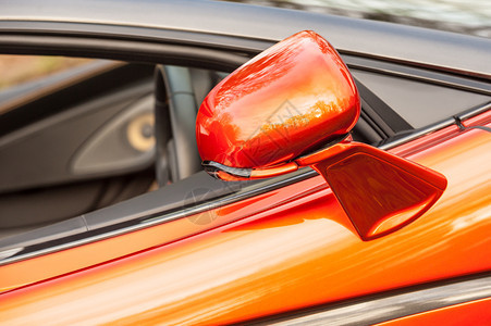 车身奢华闪亮的在一辆明橙色豪华运动车上关闭了一面驾照镜背景图片