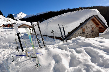 雪山上的小木屋和滑雪用具图片