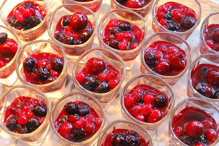 新鲜甜点有草莓果酱和樱桃在自助餐线上制玻璃新鲜的图片