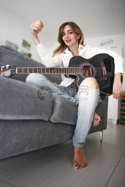 一名年轻的左手女青配有音响吉他艺术闲暇玩图片