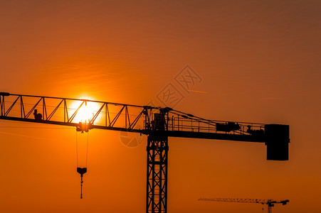 日落或出时建筑工地的起重塔船厂轮廓财产图片