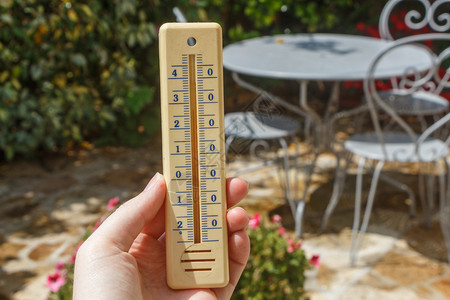 户外摄氏度一种在花园里个女人手上的温度计图片