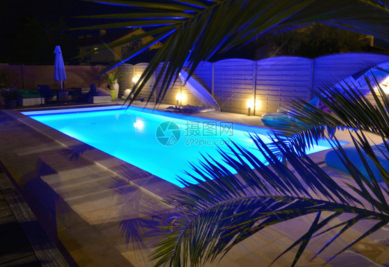 发光的闲暇家深夜照亮蓝色的游泳池水图片
