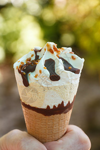 美味的香草冰淇淋配有巧克力碎块和栗子在一个女人手里甜点胡扯图片