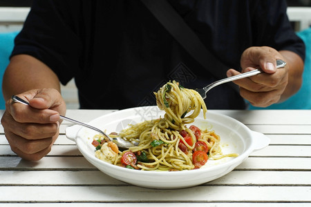 厨师食物美味的在吃意大利面时握着叉子和勺的手图片