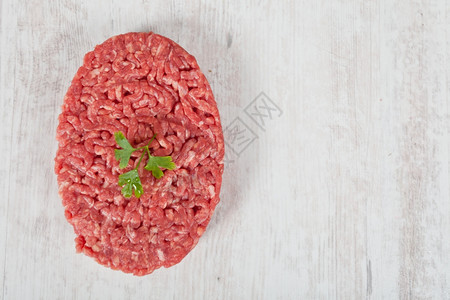 汉堡包食物红色的木制背景新鲜原生汉堡肉图片