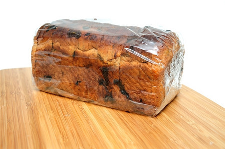 新鲜的甜小吃在木制切割板上包装了片肉桂饼面包的Loaf薄饼图片