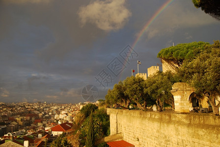 树木卡斯特罗圣豪尔赫和里斯本市的彩虹下方超过欧洲图片