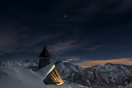 被积雪覆盖的阿尔卑斯山教堂下雪的蓝色黑暗图片