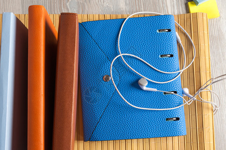 复制皱巴的蓝色笔记本桌上有耳听器和粘黏胶图片