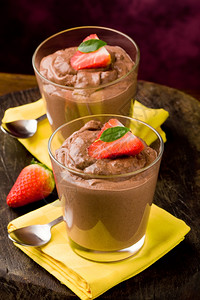 一杯美味的巧克力慕斯加草莓和黄餐巾纸摩丝甜点茶匙图片