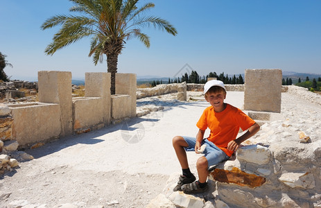 在圣经中提及的Megiddo山丘早期青铜时代的定居点遗迹上男孩废墟米吉多爬坡道图片