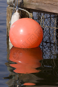 一条大型橙色浮标被绑在码头上水面反射网拉根思图片