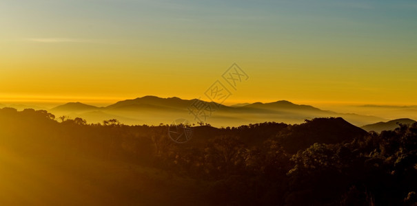 太阳多雾路段云在山风景的日出图片