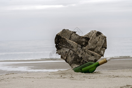 绿瓶子和沙滩上迷失的心纸邮政景观图片