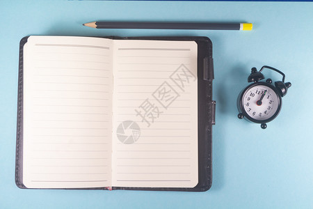 新的假期笔记本开放式和黑闹钟空白的图片