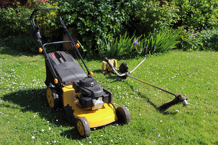 绿色草地斯特里默园艺设备割草机和在花园的剪刷机包括春间园艺设备除草机和剪梳图片