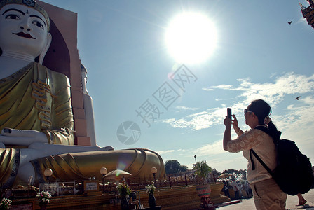 斋朋地标年轻女使用手机拍摄缅甸巴果KYAIKPUNPAYA两位布吉达人的照片帕亚图片