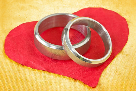 婚礼皱巴的浪漫红圆纸心上的婚戒指图片