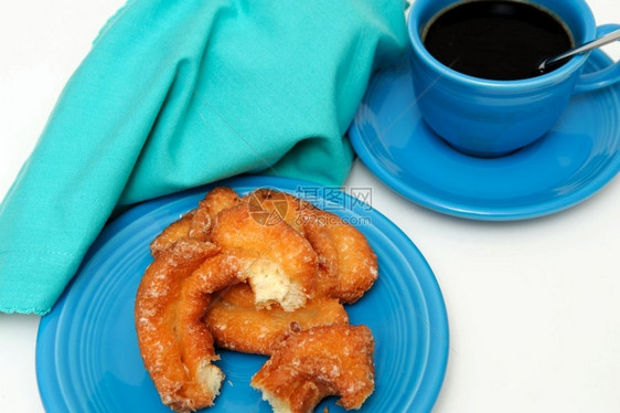 酪奶油牛甜圈配上一杯黑咖啡装在绿的彩色盘子杯和餐巾纸上食物黑色的图片