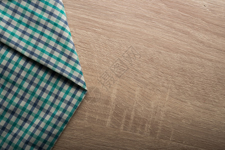 木制背景上的格子绿色餐巾纸木制背景上的格子绿色餐巾纸桌布质地空的图片