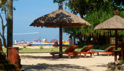 巴厘萨努尔海滩的草伞木制头巴厘岛图片