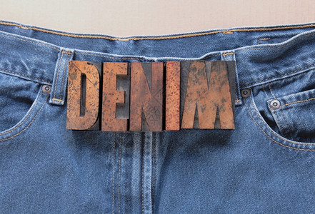 肮脏的时尚排版在旧牛仔裤上用木头字写成的benim图片
