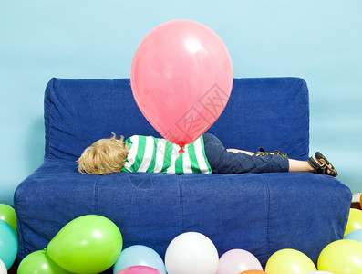 年轻男孩在生日时躺沙发上孤独派对说谎图片