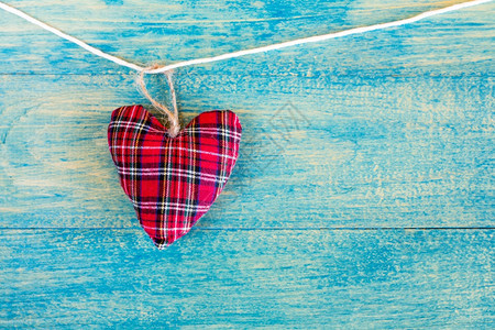 绞刑装饰织物心脏挂在蓝木背景上圣诞节丘比特图片