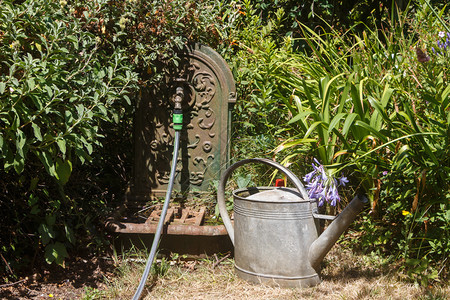 浇水轻敲锌管和喷泉中的罐在园铸铁户外图片