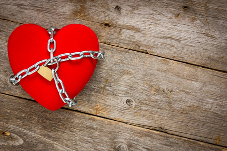 链条爱的锁闭心脏形状与铁链在木背景上安全浪漫图片