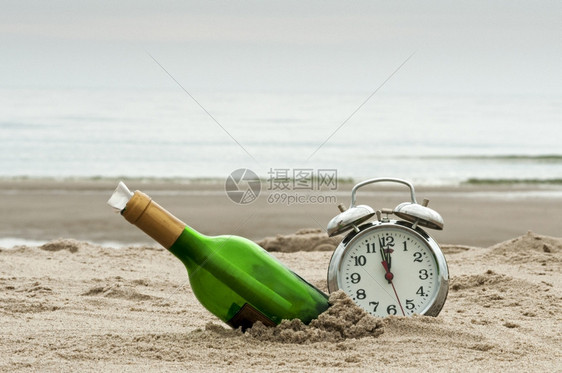 丢失纸沙滩上装有闹钟的瓶信息海滩图片