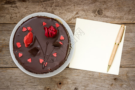 巧克力蛋糕有纸和木制背景笔的巧克力蛋糕甜点庆祝典图片