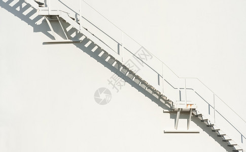 阴影栏杆漂浮在离白墙壁背景上的金属楼梯天堂图片