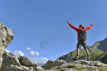 在山顶张开双手的登山者图片