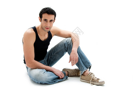 可爱的感穿着黑顶和牛仔裤的白人帅哥坐在地上与世隔绝男人图片