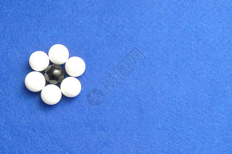白色和黑球以蓝背景孤立的花朵形状包装成白蛋和黑圆圈现代的光滑图片